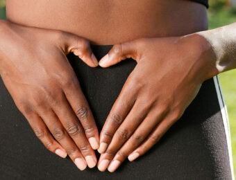 women's hands over stomach